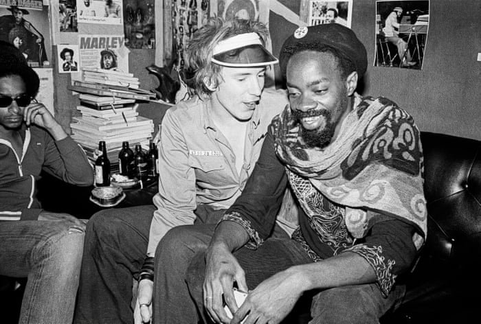 Lee Scratch Perry seated at the Black Ark studio with visitors.